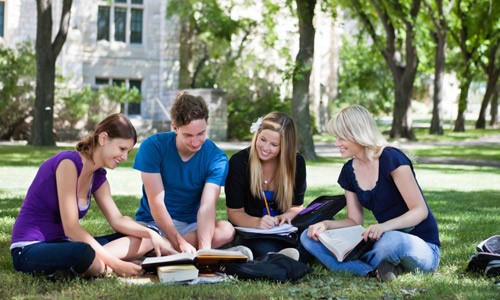 four students studying on the ground