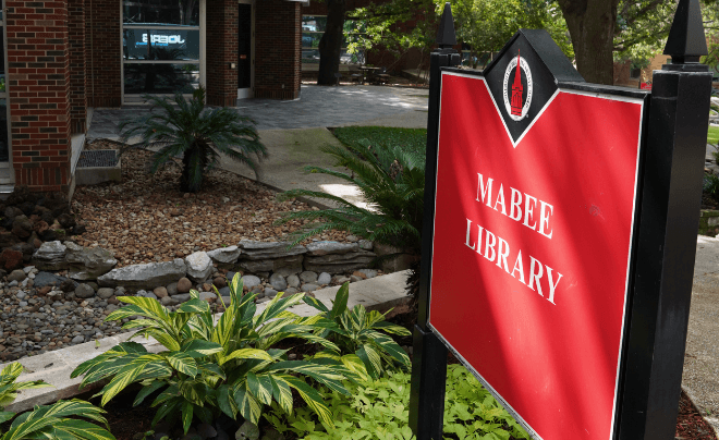 Red Mabee Library sign in front of the Mabee Library