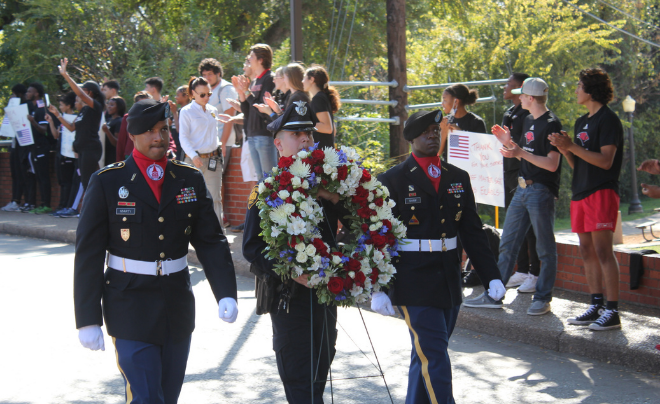 Three military members carry a wreath during the UIW Veterans Day Parade