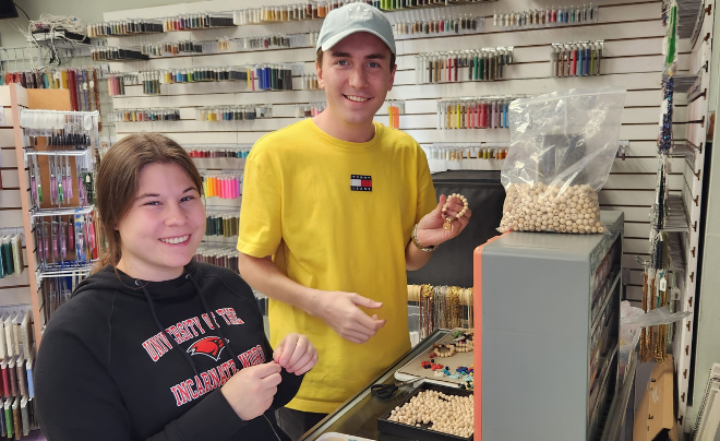 Two students help make jewelry 
