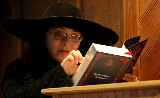 Student in black hat and glasses reading a book