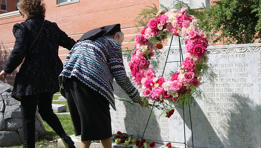 CCVI Sister placing flowers on grave
