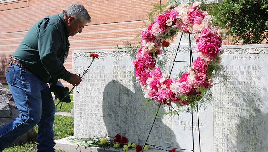 Man placing flower on grave
