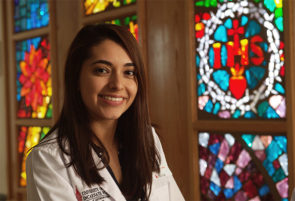 Medical student in front of stained glass window 