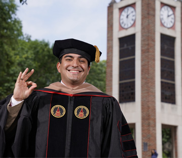 Happy Student who just Graduated in front of UIW's clock