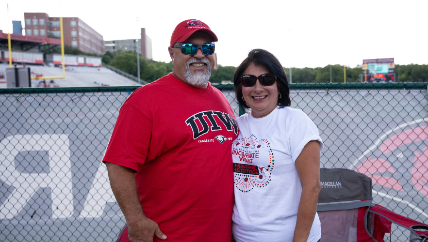 UIW parents in front of a chainlink fence