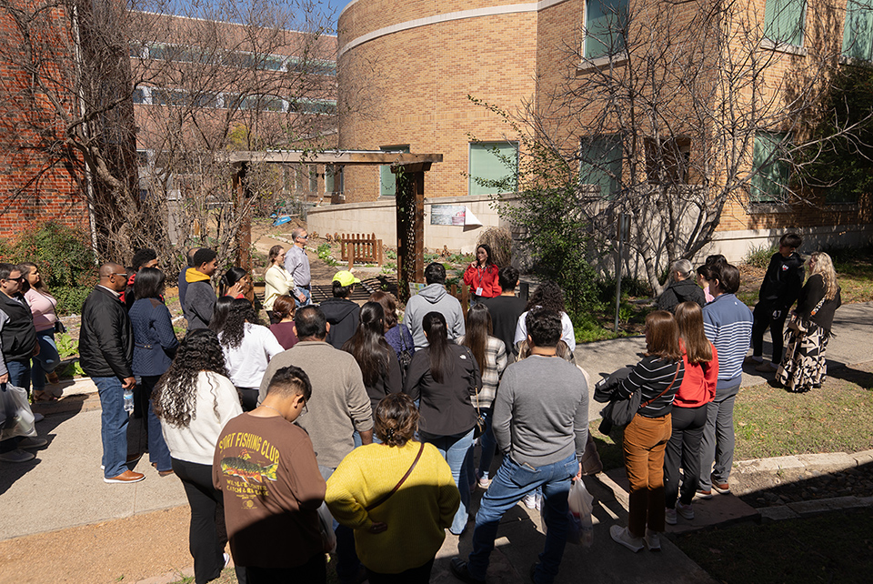 Aerial shot of campus tour guide speaking to crowd of students and parents