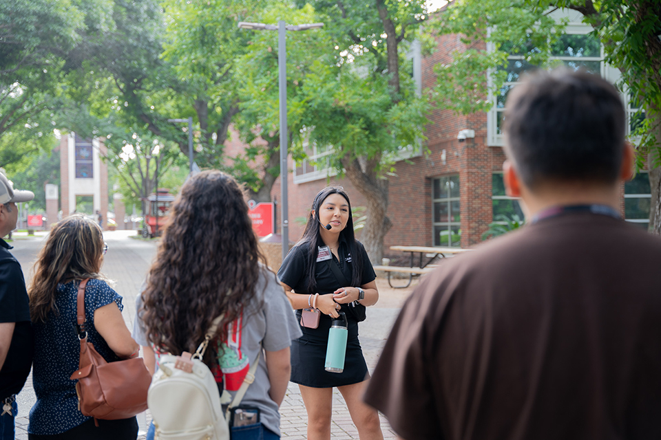 Campus tour guide giving a tour to students and parents