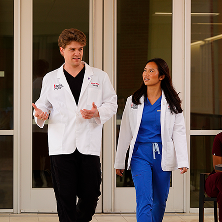 Two students in front of UIWSOM entrance