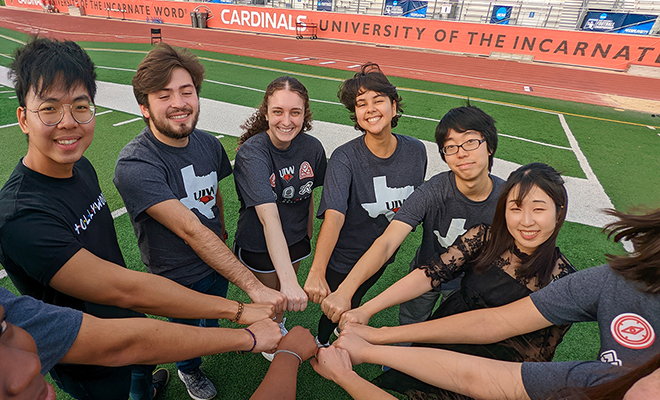 International students with hands inside a circle