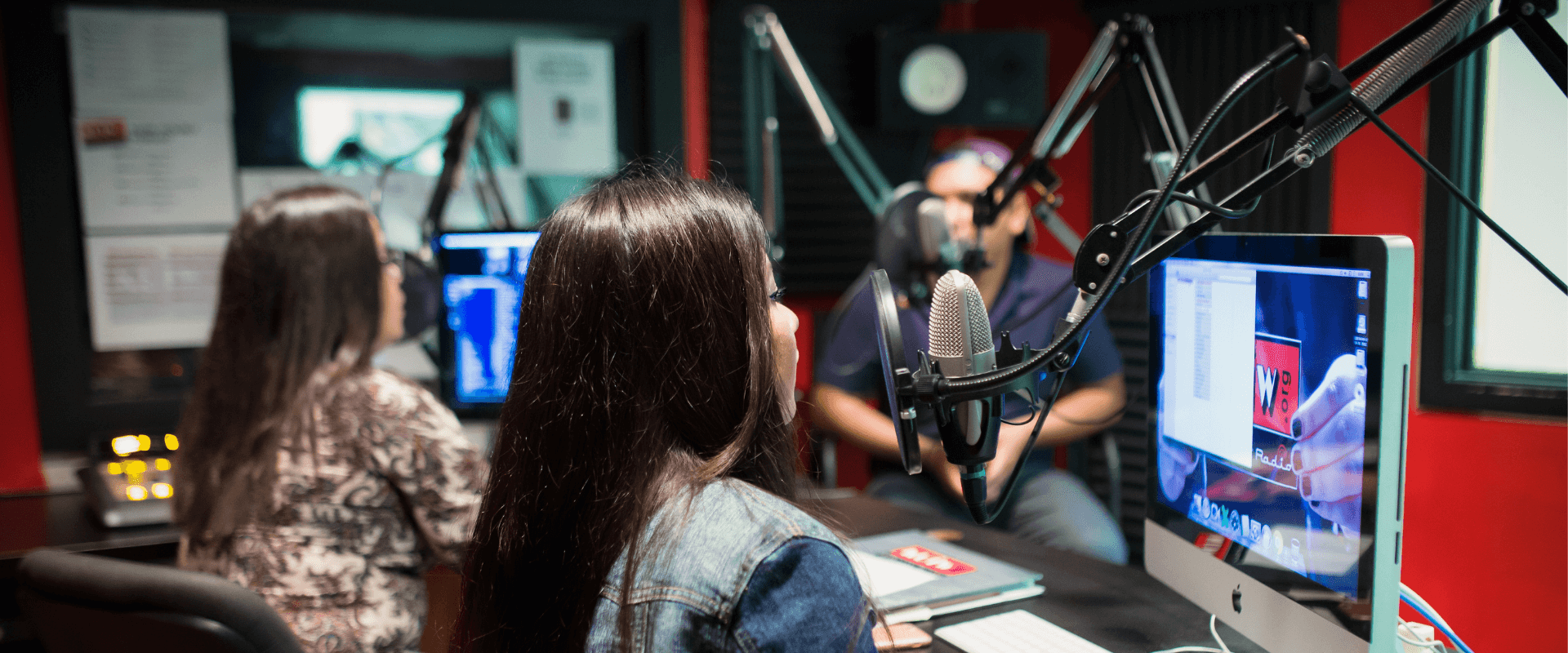 Male student filming on the back, while a female student interviews another female student for UIWtv