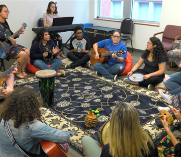 Circle of students and a teacher playing Music