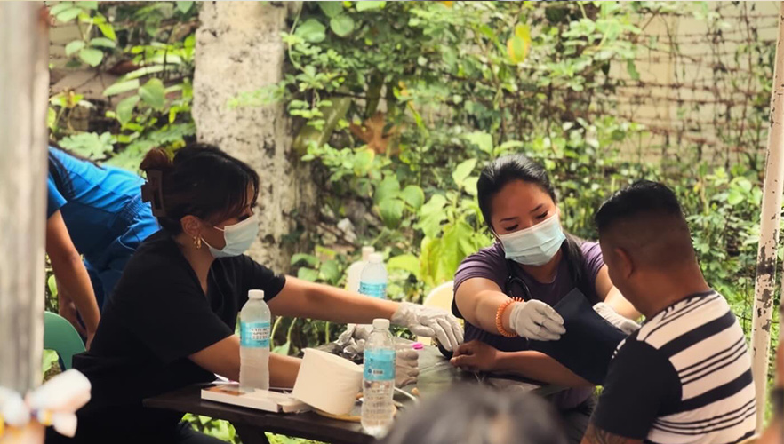 Students checking a community members blood pressure