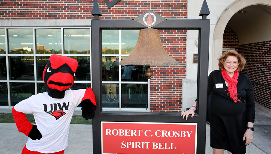 Red the Cardinal and Kate Crosby next to bell