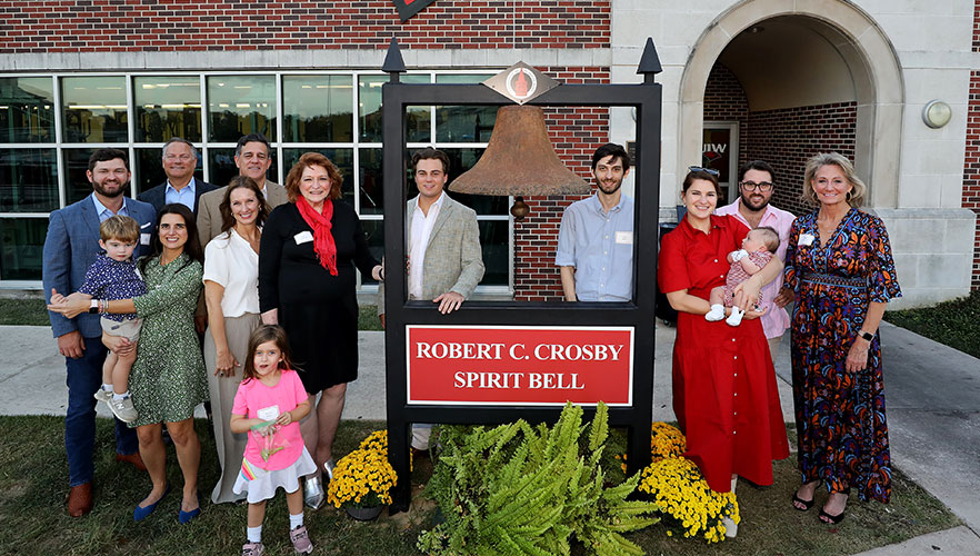 Crosby family standing around bell