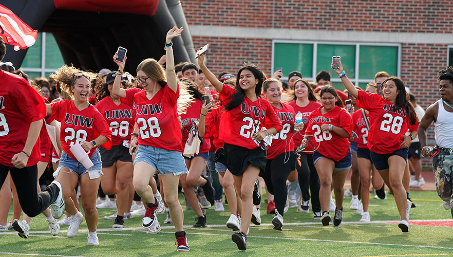 Students running across football field