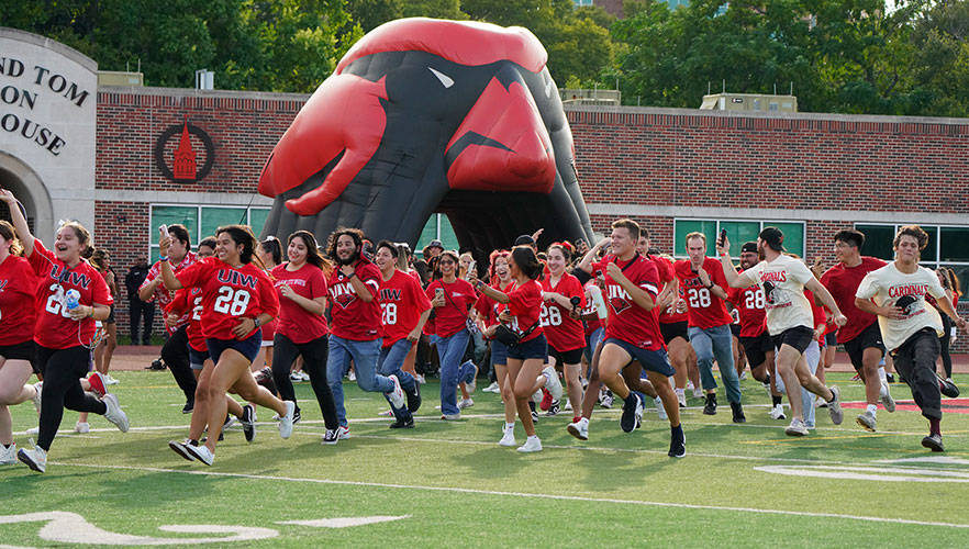 Students running across football field