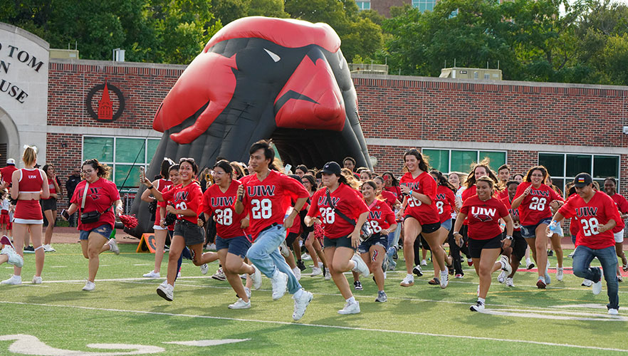 Students running across football field