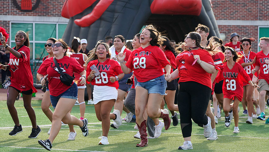 Students running across football field