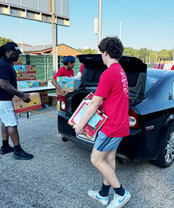 student carrying food to car