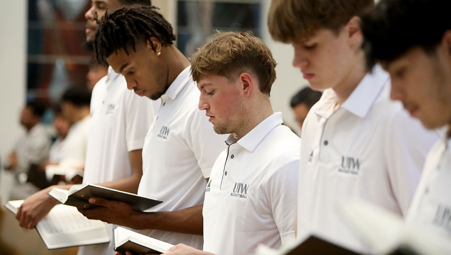 UIW basketball players praying