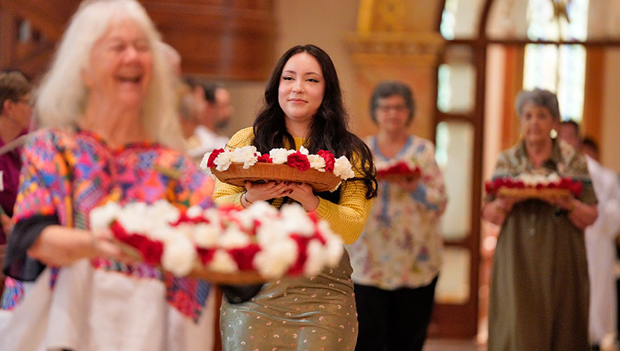 People walking down aisle with carnations