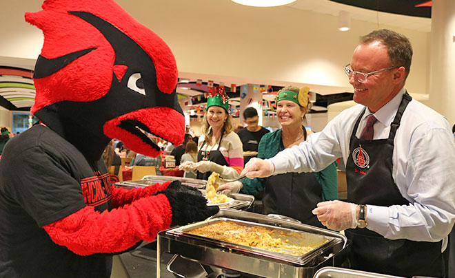 Dr. Evans serving food to Red the Cardinal