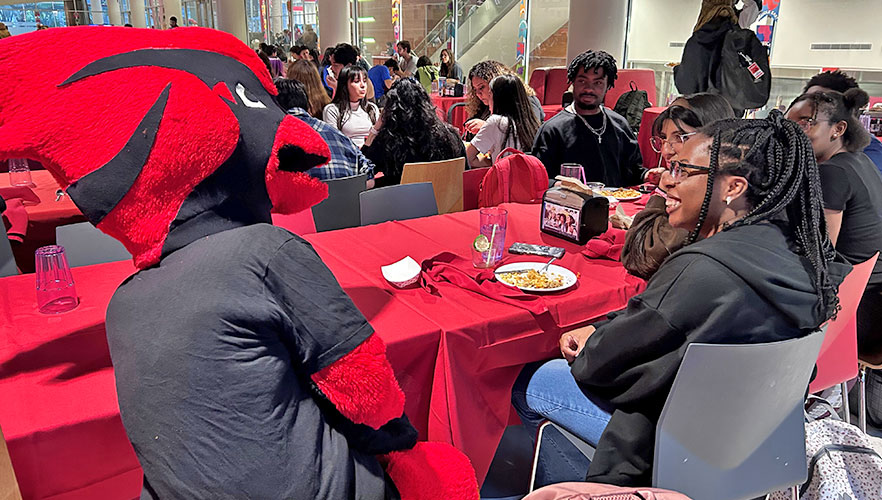 Red the Cardinal eating with student