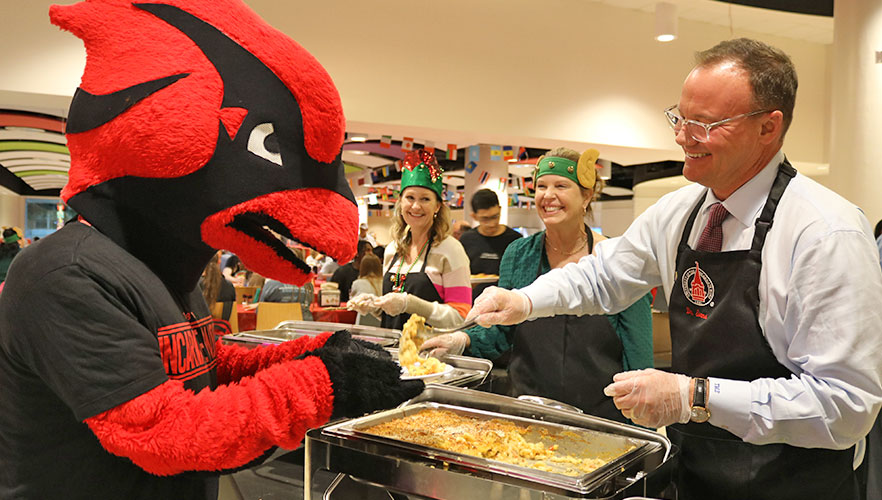 Dr. Evans serving food to Red the Cardinal