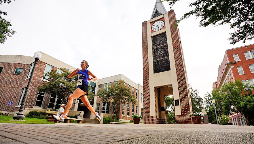 Runner running past clock tower