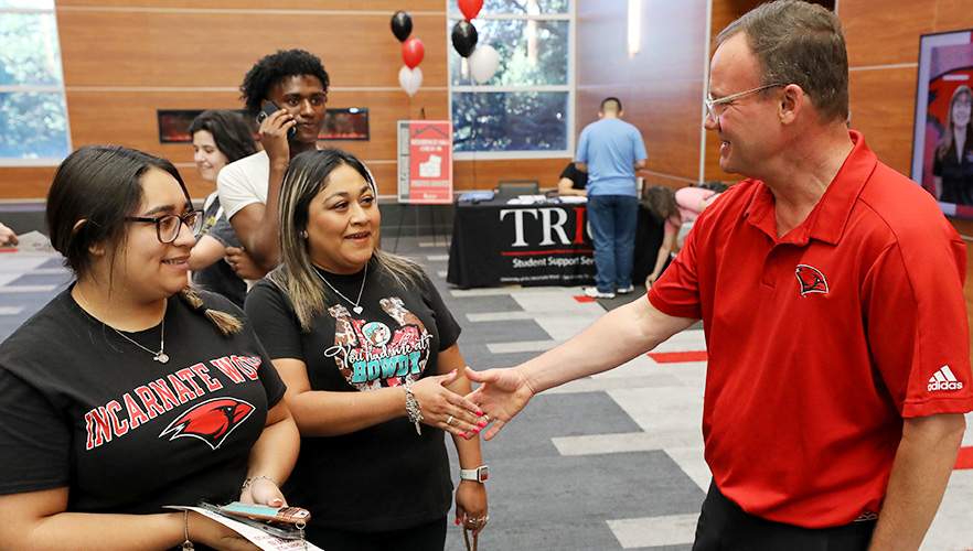 president shaking hands with students