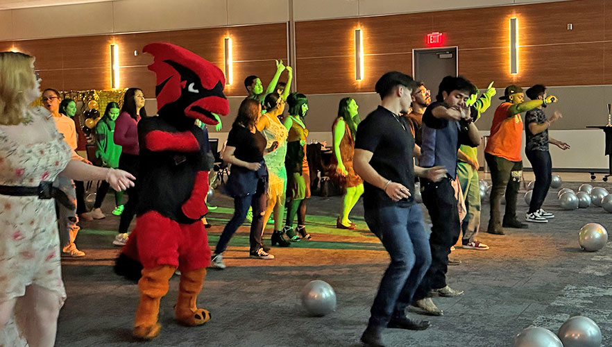 Red the Cardinal dancing with students