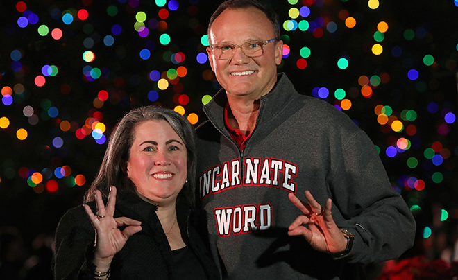 Dr. and Mrs. Evans against Christmas lights