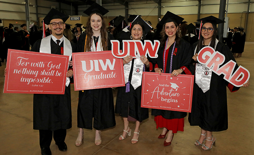 UIW graduates holding celebratory signs