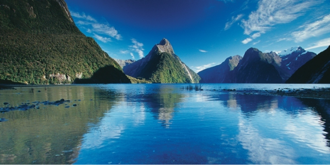 Mountains in behind the water of the sound with a deep blue sky overhead